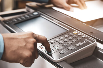 Copiers printer, Close up hand office man press copy button on panel to using the copier or photocopier machine for scanning document printing a sheet paper and xerox photocopy. - obrazy, fototapety, plakaty