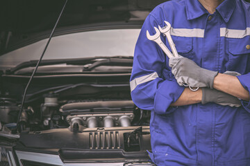 Car care maintenance and servicing, Close-up hand technician auto mechanic using the wrench to...