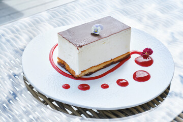 Cake souffle with chocolate icing and a flower. Shallow depth of field