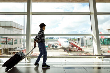 Young Air Traveller Walking To Boarding Gate Of An Airport