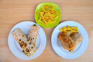 Table scene of assorted take out or delivery foods. Pizza, hamburgers, Doner, fried chicken and sides. Top down view on a table.