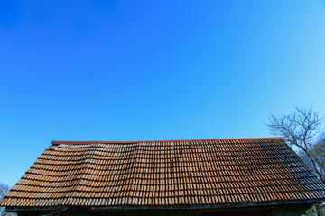 Low angle view of old shingles against a blue sky