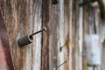 Metal cylinder on a nail nailed to a wooden wall