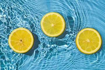Lemon citrus tropic exotic fruit in blue transparent fresh water with motion waves.