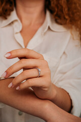 Close-up of elegant diamond ring on female finger. Love and wedding concept.Soft and selective focus.