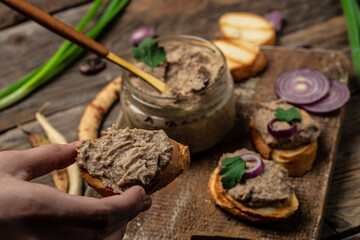 Woman hands spread bread with beans paste, Mexican cuisine pate of beans in glass jar. healthy vegetarian food, top view