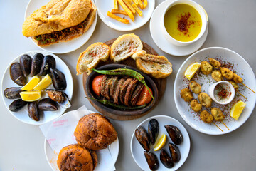 Delicious meat kebab with fresh vegetable salad served with variety of Turkish dishes and appetizers. Top view of assorted Turkish food and meze, tasty and healthy Mediterranean cuisine.