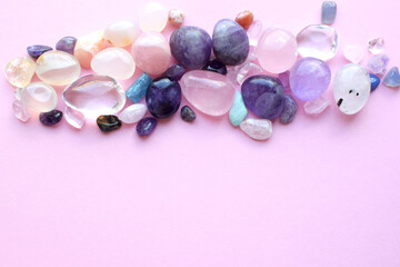 Gems of various colors. Amethyst, rose quartz, agate, apatite, aventurine, olivine, turquoise, aquamarine, rock crystal on pink background