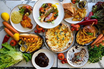 Fototapeta na wymiar Traditional Turkish cuisine. Pizza, pita, pidesi, sucuk, hummus, kebab. Many dishes on the table. Serving dishes in restaurant. Background image. Top view, flat lay
