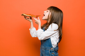 Little girl enjoying a slice of pizza