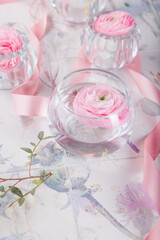 buttercup flower.rose flowers in the glasses with pink ribbon and scissors. Floral background