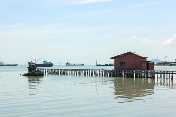 Fototapeta premium Pier with a wooden stilt house in the ancient seaside clan jetty in the UNESCO heritage town of Georgetown in Penang.