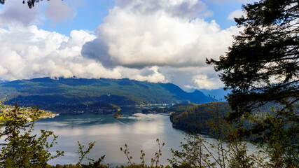 Cloud-capped, forested mountains overlooking breathtakingly beautiful BC ocean inlet.