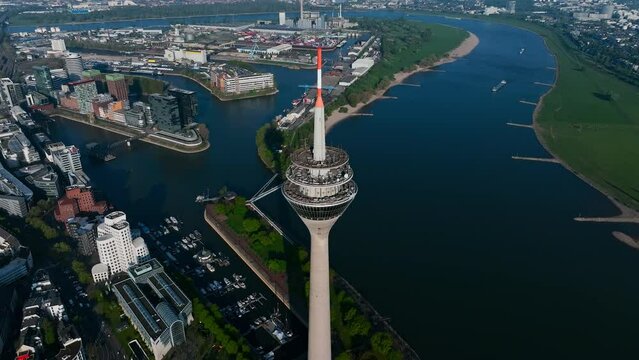 beautiful drone shot of the Rhine Tower in Düsseldorf at sunrise. The drone moves away from the Rhine Tower and opens the beautiful view of Rhine