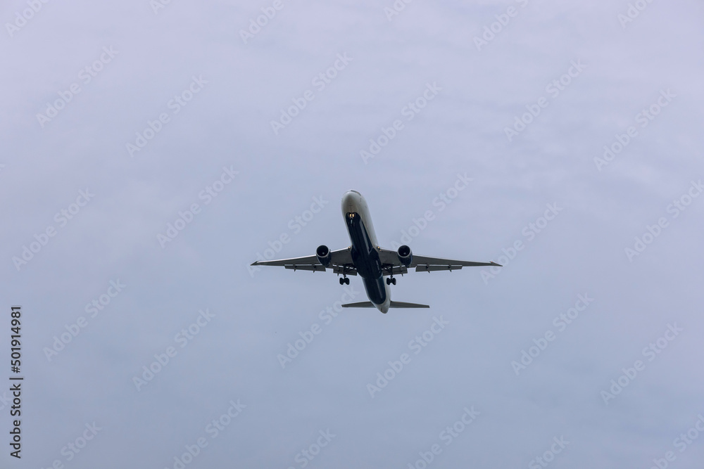 Wall mural airplane view over sky, the plane is landing at airport