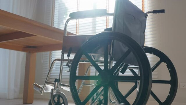 Empty Wheelchair in living room with warm sun light. Feeling Lonely, Sadness, hope concept.