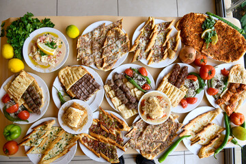 Traditional Turkish cuisine. Pizza, pita, pidesi, sucuk, hummus, kebab. Many dishes on the table. Serving dishes in restaurant. Background image. Top view, flat lay