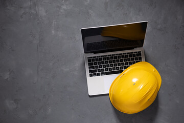 Computer laptop on cement floor. Laptop and construction tools