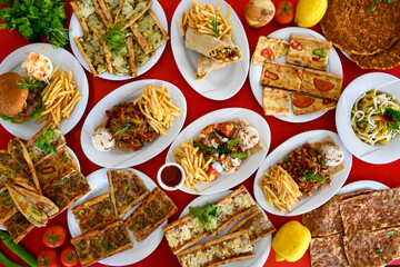 Table scene of assorted take out or delivery foods. Pizza, hamburgers, Doner, fried chicken and sides. Top down view on a table.