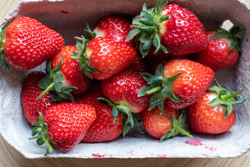 food background of a punnet of delicious fresh organic strawberries 