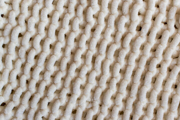 white knitting background featuring hand knit fabric in soft super chunky yarn 