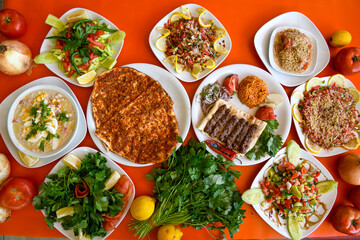 Traditional Turkish cuisine. Pizza, pita, pidesi, sucuk, hummus, kebab. Many dishes on the table. Serving dishes in restaurant. Background image. Top view, flat lay