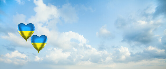 Sky clouds background with two balloons with Ukrainian flag. Love Ukraine concept