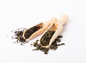 Green and black tea in slides and in a wooden spoon isolated on a white background. Dry tea leaves...
