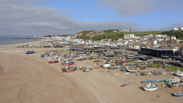 Aerial footage of Hastings Stade Beach towards the largest land based fishing fleet in Europe with local boats and equipment in view.