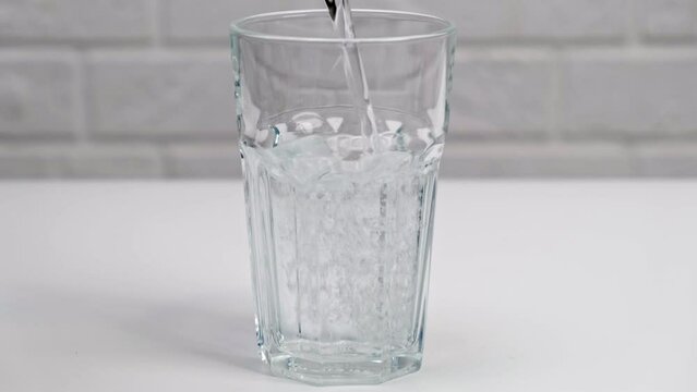 Pouring clear sparkling water into a glass. Close up.