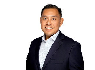 Hispanic man in business suit smiling at the camera on a white background