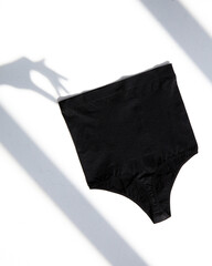 Top view women's cotton black color panties isolated on sunny white. Flat lay