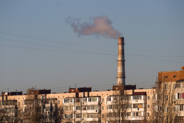Pipes of an old factory throw clouds of poisonous white smoke into the sky polluting the...