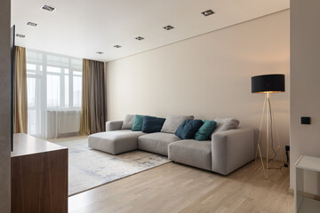 big gray sofa in a modern apartment, living room interior
