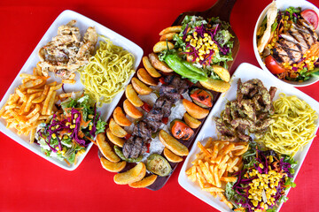 Delicious meat kebab with fresh vegetable salad served with variety of Turkish dishes and appetizers. Top view of assorted Turkish food and meze, tasty and healthy Mediterranean cuisine.