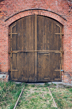 old wooden door in a brick wall of the locomotive stable of former Skreia Station, Toten, Norway. 