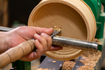 Closeup of carpenter turning wood on a lathe