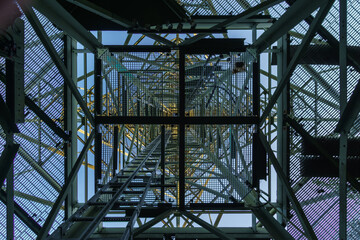Looking up through metal frames of an old radio tower