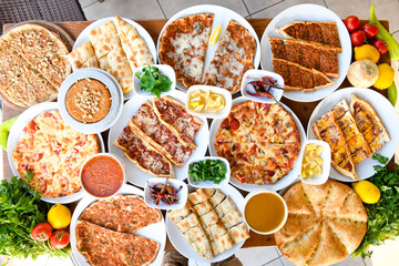 Traditional Turkish cuisine. Pizza, pita, pidesi, sucuk, hummus, kebab. Many dishes on the table....