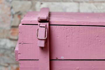 A fragment of a massive pink wooden chest in vintage style