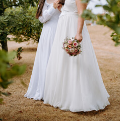 Fototapeta na wymiar Lesbian brides holding wedding bouquets