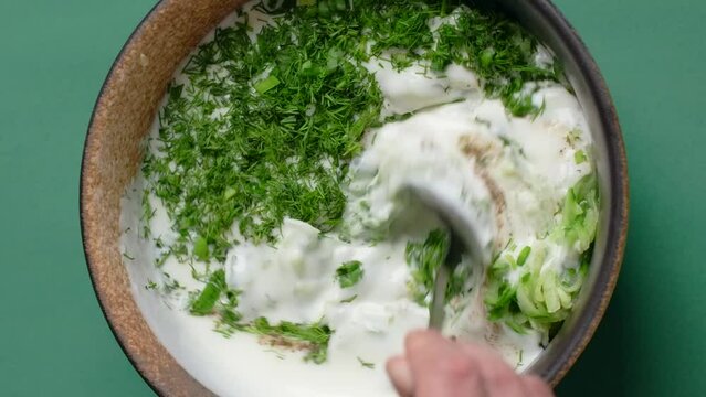 Vertcial flat lay cooking food: making cold soup with kefir and grated cucumber