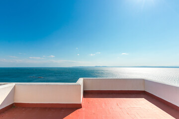 White terrace with red floor and sea view on a sunny day. - obrazy, fototapety, plakaty