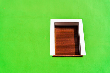 Green wall with brown wooden window.