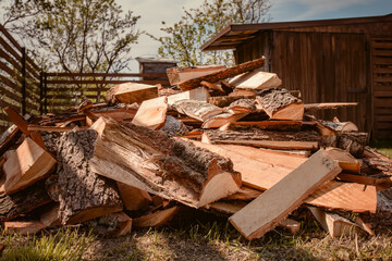 Large pile of birch wood. Remains of woodworking production stacked on the ground near the fence