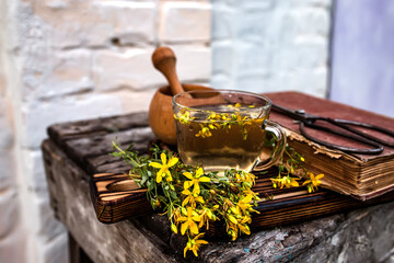 Fototapeta na wymiar Still life of medicinal herbs. An old wooden mortar with dry herbs for the preparation of medicinal teas. Book of recipes of alternative medicine