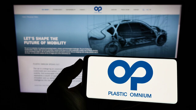 Stuttgart, Germany - 03-06-2022: Person holding smartphone with logo of French company Compagnie Plastic Omnium SA on screen in front of website. Focus on phone display.
