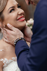 Groom touches bride's neck tender before a kiss