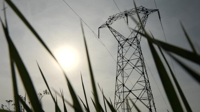 Ligne haute tension avec un soleil couchant - Plan en 4K
