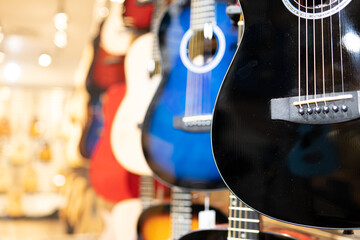 Guitars on display in music instruments store in a mall - obrazy, fototapety, plakaty